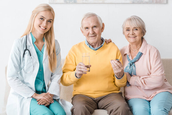 young female doctor giving medicine to senior patients 