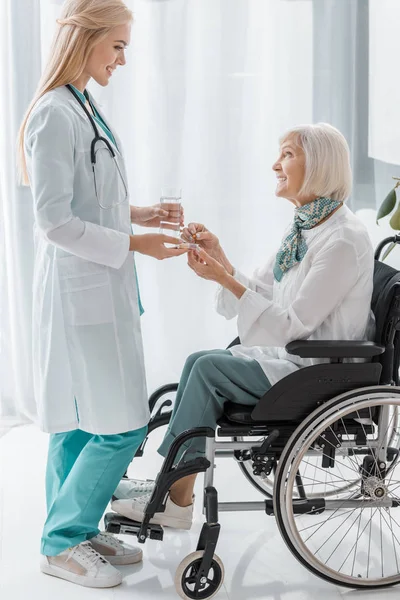 Young Female Doctor Giving Pills Disabled Senior Woman — Stock Photo, Image