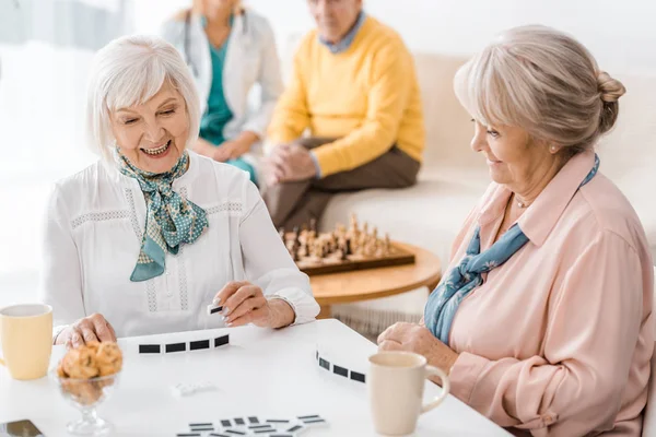 Starší Ženy Hrají Domino Bílá Stolu Pečovatelském Domě — Stock fotografie