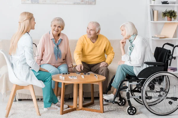 Jovem Enfermeira Jogando Dominó Com Pacientes Seniores — Fotografia de Stock