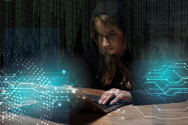 portrait of woman in black hoodie using laptop, cyber security concept