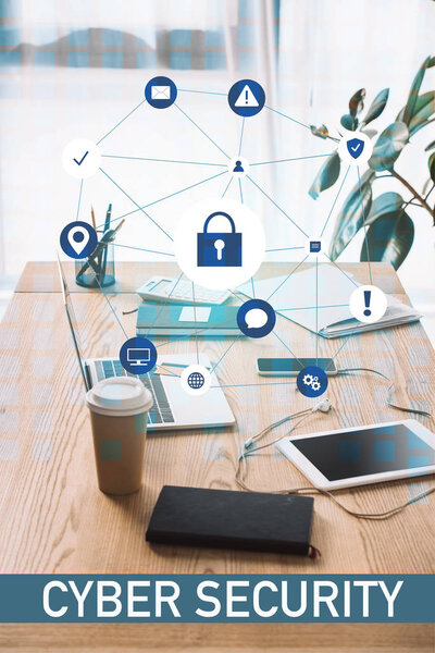 закрытый вид на знаки кибербезопасности, рабочее место с ноутбуком, кофе и ноутбук
