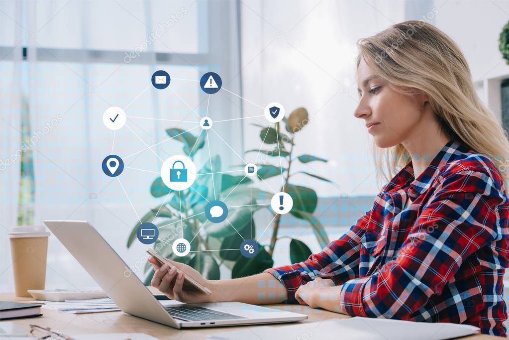 side view of businesswoman using smartphone at workplace in office, cyber security concept