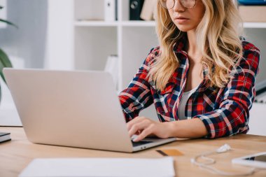 kredi kartı ve kağıtları ile masa laptop yazarak kadının kısmi görünümü