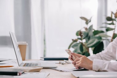 işkadını belgeler ve office içinde laptop ile işyerinde smartphone ile kısmi görünümünü