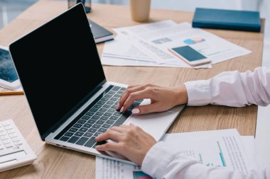 iş kadını ofiste işyerinde boş ekran ile dizüstü bilgisayar üzerinde çalışan kısmi görünümünü