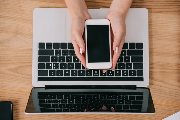 Colpo Ritagliato Donna Che Tiene Smartphone Mano Tavolo Con Computer — Foto Stock