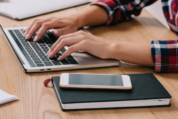 Partial View Woman Typing Laptop Tabletop Smartphone Notebook — Stock Photo, Image