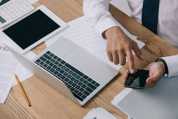 Partial View Businessman Using Smartphone Tabletop Documents Laptop — Stock Photo, Image