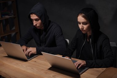 siyah hoodies ahşap masa üstü, siber güvenlik kavramı dizüstü bilgisayarlar kullanarak kesmek