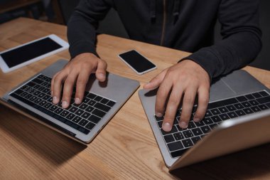 Masa üstü smartphone ve tablet, siber güvenlik kavramı ile dizüstü bilgisayarlar kullanarak hacker kısmi görünümü