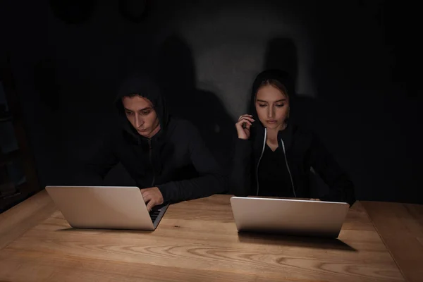 Hackers Capuzes Pretos Usando Laptops Mesa Madeira Quarto Escuro Conceito — Fotografia de Stock