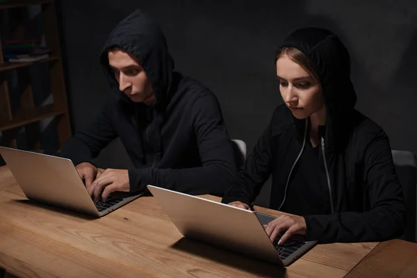 Hacker Schwarzen Kapuzenpullovern Mit Laptops Hölzerner Tischplatte Cyber Sicherheitskonzept — Stockfoto