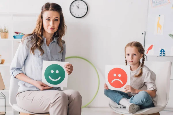 成人心理学家和孩子举行快乐和悲伤的情感面孔卡片 — 图库照片