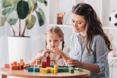 psikolog otizm sendromu olan küçük çocuk Legolarla oynuyor