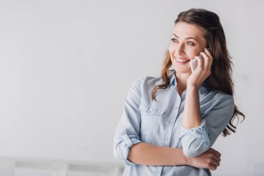 close-up portrait of smiling adult woman talking by phone and looking away clipart