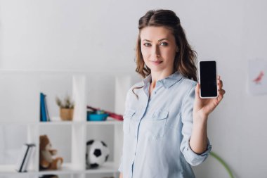 kameraya smartphone boş ekran ile gösterilen gömlek gülümseyen yetişkin kadın
