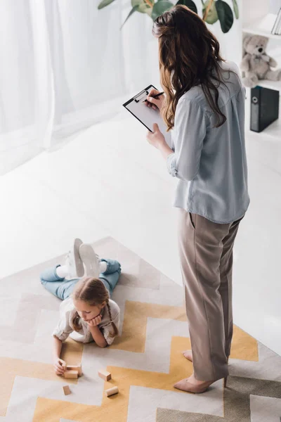 High Angle View Psychologist Clipboard Standing Child While She Lying — Stock Photo, Image