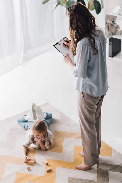 Vue Grand Angle Psychologue Avec Presse Papiers Debout Près Enfant — Photo