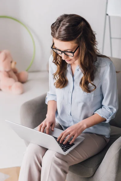 Hoge Hoekmening Van Kinderpsycholoog Zitten Een Leunstoel Werken Met Laptop — Stockfoto