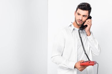 close up of handsome man talking on retro red telephone  clipart