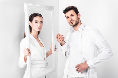 çerçeve yakışıklı adam yakınındaki beyaz arka plan üzerinde tutan güzel yetişkin kadın 