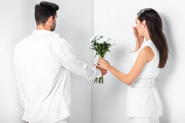 Close Man Giving Flowers Surprised Woman Total White — Free Stock Photo