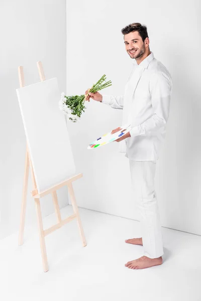 Descalzo Artista Masculino Dibujo Blanco Total Caballete Con Ramo Flores — Foto de stock gratis
