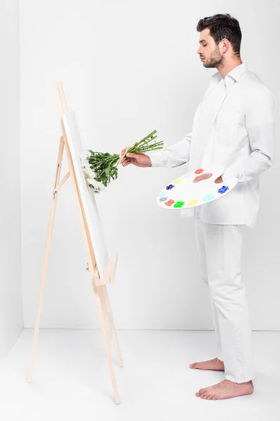 Descalço Artista Masculino Total Branco Desenho Cavalete Com Buquê Flores — Fotos gratuitas