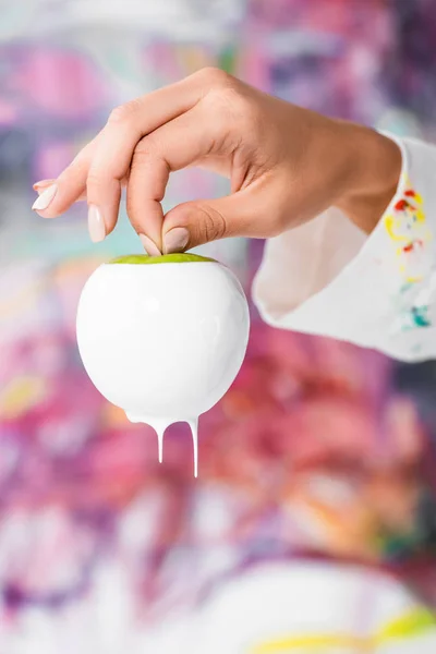 Close Female Hand Holding White Painted Apple — Free Stock Photo