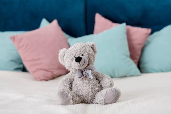 Teddybär Sitzt Auf Dem Bett Mit Kissen Auf Dem Hintergrund — Stockfoto