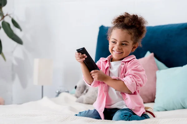 Smiling Curly African American Kid Sitting Bed Remote — Stock Photo, Image