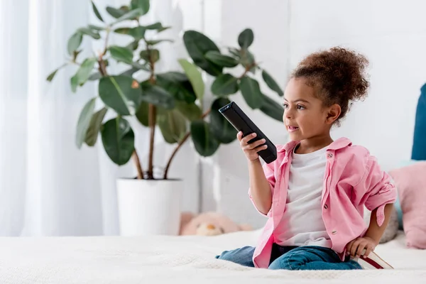 Adorable African American Child Sitting Bed Switching Channels — Free Stock Photo