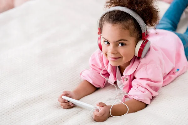 Smiling African American Child Lying Bed Listening Music Her Smartphone — Stock Photo, Image
