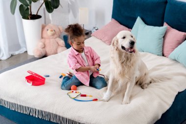 Doktor onun köpeği ile oynayan kıvırcık Afro-Amerikan çocuk