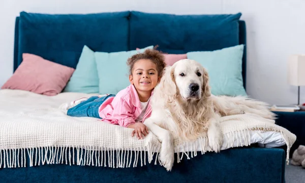 Sonriente Niña Afroamericana Acostada Cama Con Golden Retriever — Foto de Stock