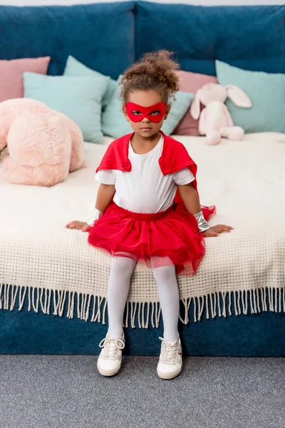 Lindo Niño Afroamericano Traje Superhéroe Rojo Máscara Sentado Cama — Foto de stock gratis