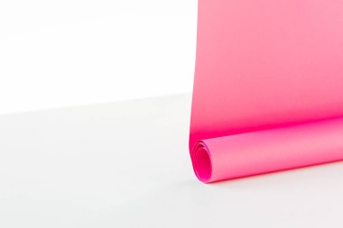 close up of bright rolled out pink paper hangings on white background clipart
