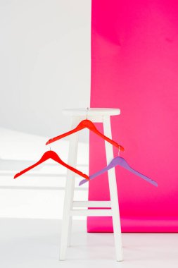 multicolored painted hangers with white wooden chair clipart