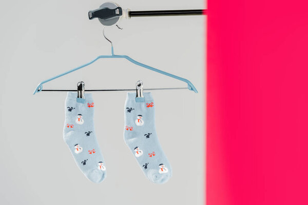 pair of blue cotton socks with winter pattern on grey and pink background