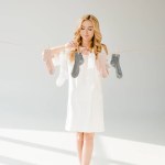 Beautiful woman with socks hanging on clothesline