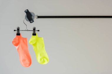 pair of multicolored socks on hanger isolated on grey clipart