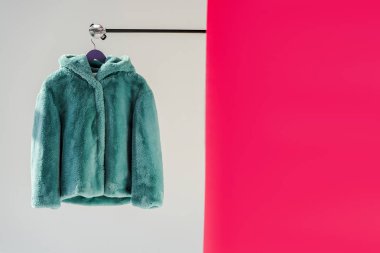 kabarık yeşil faux kürk palto askısı ile pembe duvar kağıdı üzerinde Kapat 