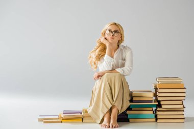 beautiful dreaming barefoot woman in glasses sitting on steps made of books  clipart