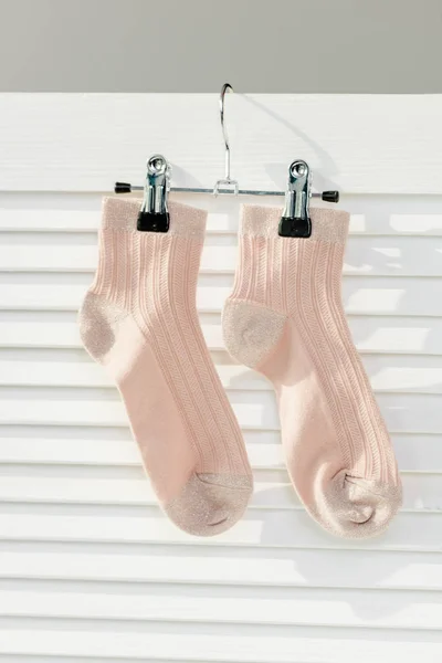 Nahaufnahme Von Rosa Socken Die Einem Weißen Raumteiler Hängen — kostenloses Stockfoto