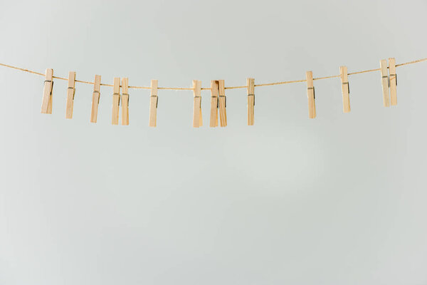 крупным планом из сырой деревянной одежды, висящей на веревке, изолированной на сером
