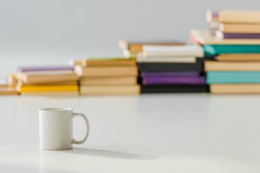 ile yaşlı yığın kitap arka plan üzerinde beyaz Kupası kapatın