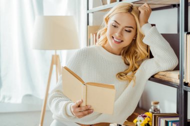 kitap raf yakınındaki okuma güzel gülümseyen kadın kapatmak