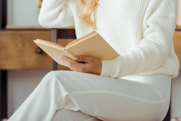 close up of elegant woman holding and reading book