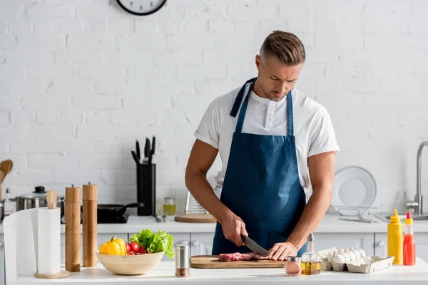 Mature Man Cutting Meat Dinner Kitchen — Stock Photo, Image